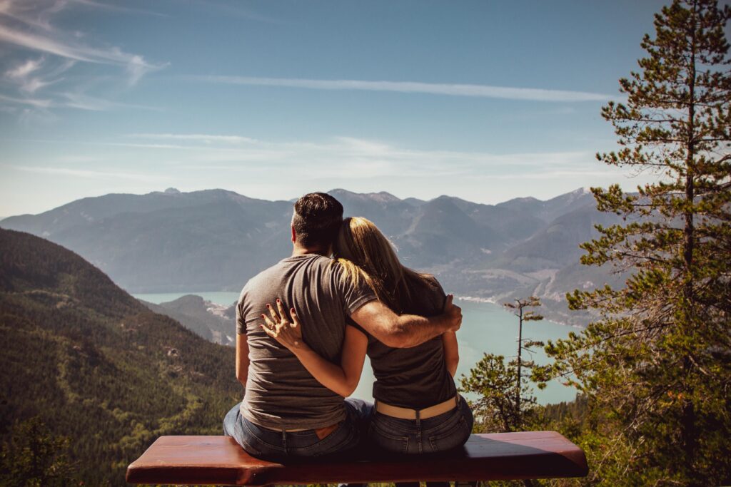 A couple hugging and enjoying a view, illustrating relationship goals and the key traits of a healthy relationship like communication, trust, and growth.